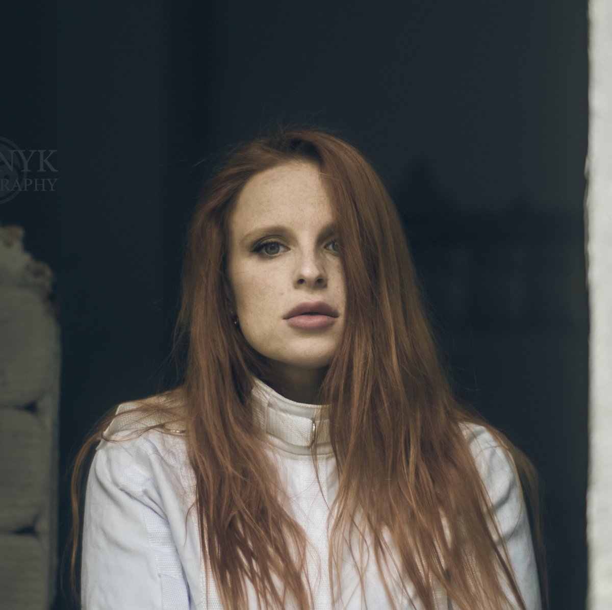 Redhead in straitjacket bondage by window